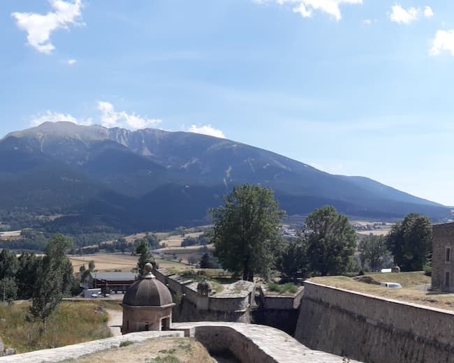In the height of summer, from the defensive walls of the citadel of Mont-Louis, the view of Cambre d’Aze without snow and the plain of Saint-Pierre-dels-Forcats