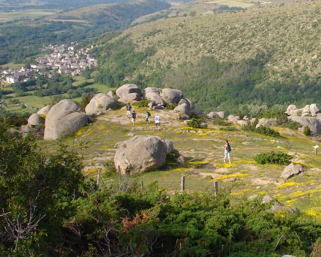 Un groupe de randonneurs marche au travers des rochers du chaos granitique de Targasonne.
