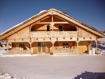 Chalet Ker Carlit and its snow-covered garden under the sun and blue sky of French Cerdagne.